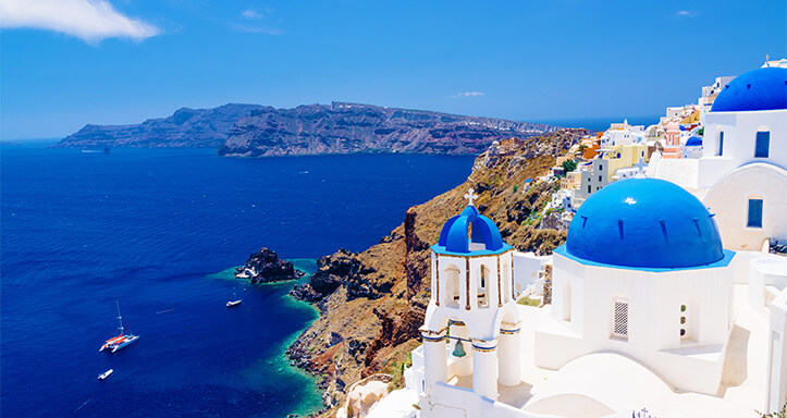 Griechische Architektur am Meer mit weißen Häusern und blauen Kuppeln